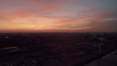 Drohnenflug-Aus-Der-Luft-über-Den-Fluss-Amsterdam-Ij-Während-Des-Orangeroten-Sonnenunterganghimmels,-Niederlande