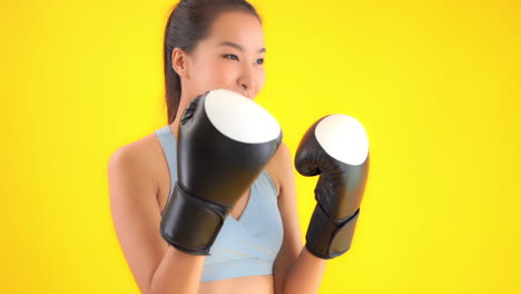 Nahaufnahme-Einer-Asiatischen-Frau-Mit-Boxhandschuhen,-Fitnesstraining-Und-Gesundem-Lifestyle-Konzept,-Isoliert-Auf-Gelbem-Hintergrund
