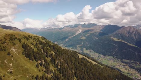 Drone-shot-fly-over-a-mountain-looking-over-a-valley-in-the-distance-in-Switzerland-in-4k