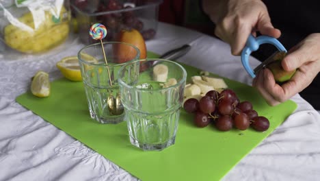 Schälen-Einer-Kiwi-Für-Ein-Frisches-Obstfrühstück-Mit-Trauben,-Statische-Kamera