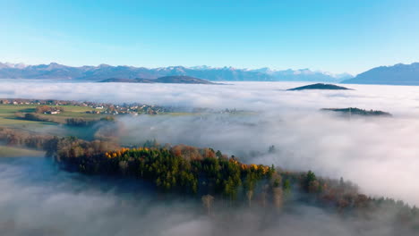 Misty-woodlands-and-pastures-on-the-Swiss-Plateau-with-Savigny-village-in-Vaud,-Switzerland---aerial-drone-shot