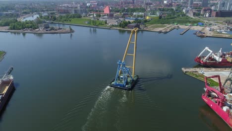 A-Floating-Crane-Sailing-On-The-Water-In-Gdansk,-Poland-Near-The-Gdansk-Shipyard---aerial-drone