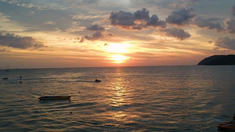 Flying-drone-into-beautiful-sunset-reflecting-in-the-ocean-at-Pantai-Cenang-in-Langkawi-Malyasia
