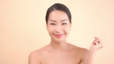 Glückliche-Zufriedene-Asiatin-Nach-Kosmetischer-Hautpflege-Und-Spa-behandlung,-Die-Ihr-Gesicht-Berührt,-Nahaufnahme-Slowmotion