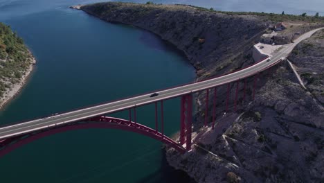 Puente-De-Arco-Rojo-Maslenica-En-Croacia-Con-Coches-Conduciendo,-Mar-De-Novigrad,-Antena