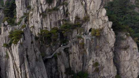 People-on-Yellow-Mountain-walkway,-Huangshan-Anhui-province-China,-lowering-aerial-view