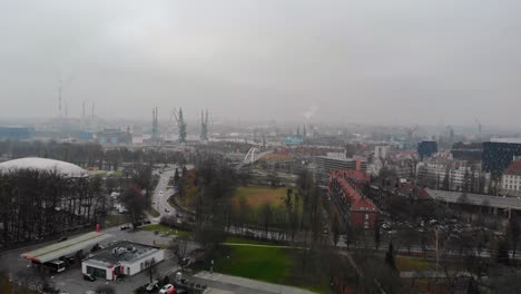 Panorama-Aéreo-De-La-Ciudad-De-Gdansk,-Polonia-Con-Grúas-Portuarias-Y-Chimeneas-De-Fábrica