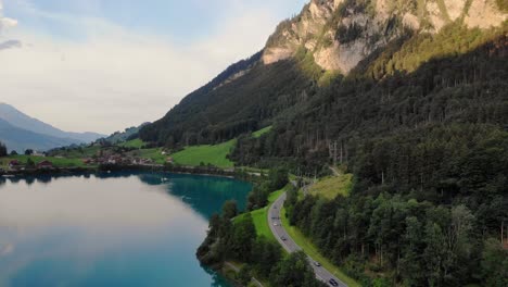 Car-drive-scenic-road-on-coast-of-Lungernersee-lake-in-Swiss-Apls,-aerial-view