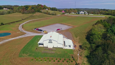 Aerial-view-orbiting-barn-turned-to-wedding-venue-in-countryside,-4K