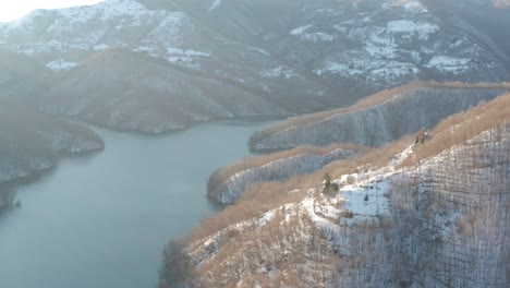 Aerial-view-of-a-lake-surrounded-by-the-snow