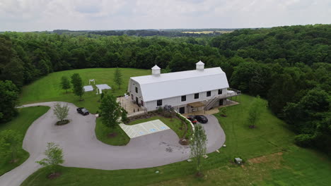 Aerial-over-barn-that-has-been-converted-upscale-wedding-venue,-4K