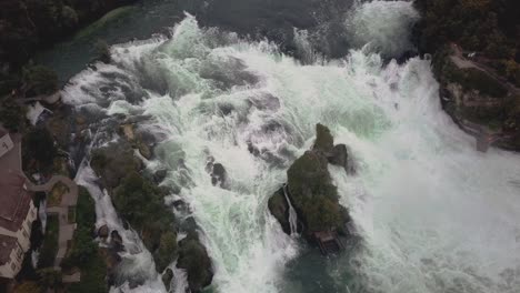 Drohnenaufnahme-Fliegt-Mit-Nach-Unten-Geneigter-Kamera-über-Den-Großen-Wasserfall-Rheinfall-In-Der-Schweiz-In-4k