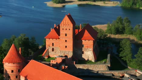 Castillo-Medieval-De-La-Isla-De-Trakai-Con-Muros-De-Piedra-Y-Torres-En-El-Lago-Galve,-Lituania---Retroceso-Aéreo