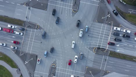 Cars-crossing-intersection-in-city-center-Reykjavik,-top-down-aerial