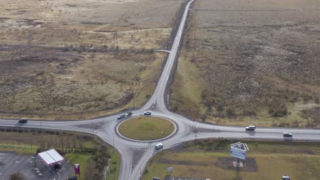 Remote-small-town-roundabout-in-Iceland,-boundless-straight-road,-aerial