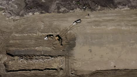Top-down-aerial-shot-of-heavy-equipment-working-on-a-dirty-construction-job-site