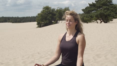Schöne-Frau,-Die-In-Friedlichen-Sanddünen-Meditiert