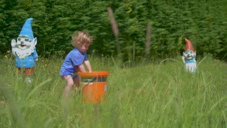 Slow-motion-shot-of-toddler-splashing-water-from-a-bucket-on-a-hot-summer-day