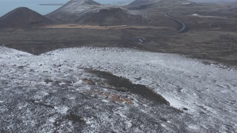 Snowy-landscape-with-volcanic-mountain-cones-in-spectacular-Iceland-terrain,-aerial