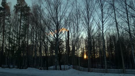 White-smoke-coming-out-of-a-tall-chimney-during-sunset-on-a-cold-winter-day-in-Sweden-while-cars-passing-by-in-the-foreground