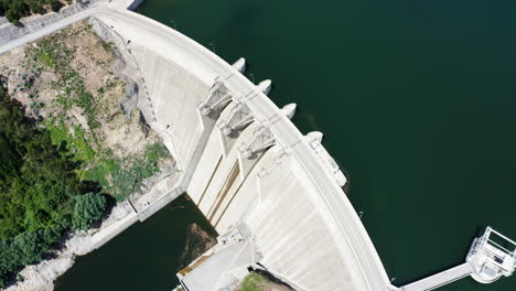 Top-down-Shot-Of-The-Ribeiradio-Dam-Structure-In-Vouga,-Portugal-On-A-Sunny-Day---aerial-drone