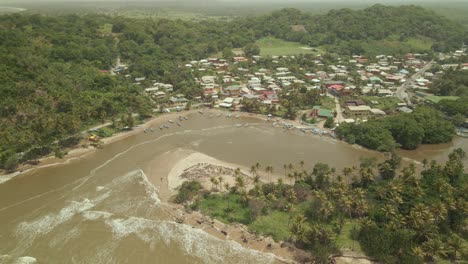 Epic-aerial-of-fishing-boats-anchored-in-the-harbour-as-the-Atlantic-ocean-meet-the-Ortiore-river-on-the-island-of-Trinidad