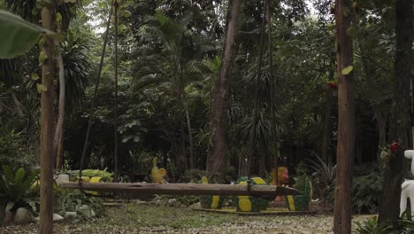 Un-Columpio-Vacío-En-Medio-De-Un-Jardín-Tropical,-El-área-Forestal-Rodeada-De-árboles-Y-Follaje-Verde-Fresco-En-Kanchanaburi,-Tailandia