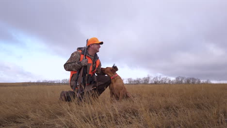 A-Hunter-With-Rifle-Gun-Goes-Hunting-With-His-Pet-Dog-In-The-Wilderness-In-Saskatchewan,-Canada---full-shot