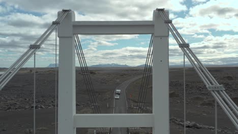 Flying-through-steel-tower-of-remote-suspension-bridge-in-Iceland,-aerial