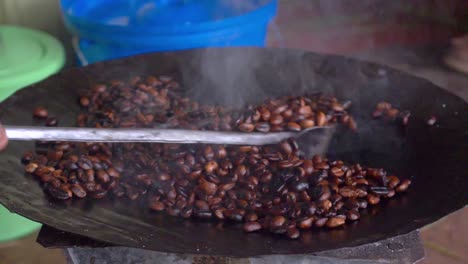 Slow-motion-shot-for-the-coffee-beans-being-roasted-and-turned-into-the-dark-color,-this-is-sign-they-are-ready-to-be-turned-into-delicious-drink