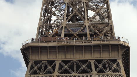 Torre-Eiffel-En-París,-Primer-Plano-Del-Mirador-Del-Segundo-Piso-Lleno-De-Turistas,-Vista-De-ángulo-Bajo-Desde-El-Suelo