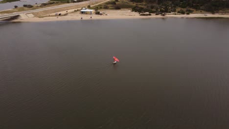 Birds-eye-view-of-wind-surfer,-sailing-alone-on-the-waters-of-Laguna-Garzon