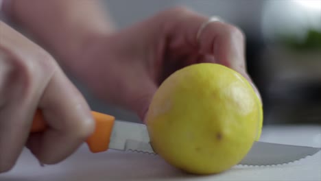 Zitrone-Mit-Einem-Messer-Auf-Einem-Schneidebrett-Schneiden