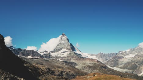 Timelapse-of-clouds-moving-against-the-Matterhorn-mountain-with-clear-blue-sky-in-Switzerland-in-4k