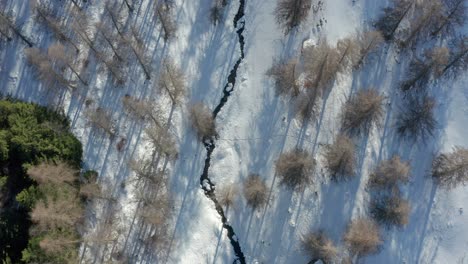 drone-flying-above-the-mountains-during-winter,-forward-movement-tilting-up