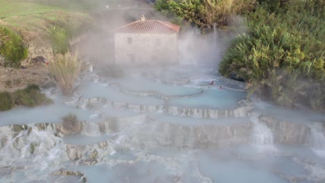 Serene-tourist-attraction-natural-sulfur-hot-spring-in-Italian-countryside,-aerial