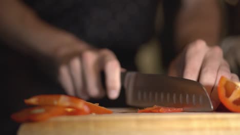 Slicing-A-Red-Bell-Pepper-Into-The-Wooden-Chopping-Board