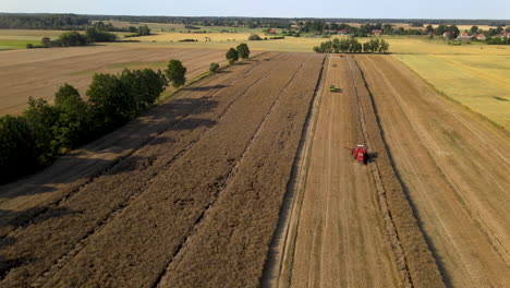 Luftaufnahme-Von-Mähdreschern-Auf-Landwirtschaftlichen-Weizenfeldern,-Rückwärtsflug