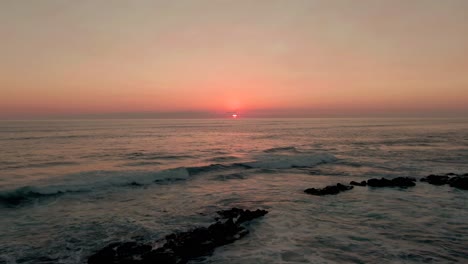 Luftbild-Mit-Rückwärtsbewegung-Des-Rosafarbenen-Sonnenuntergangs,-Der-Sich-Im-Karibischen-Ozean-Widerspiegelt