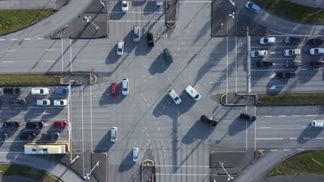 Cars-moving-along-on-intersection-during-sunny-day,-aerial