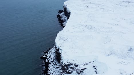 Island-Küstenlandschaft-Im-Winter-Mit-Weißem-Schnee-Bedeckt,-Antenne