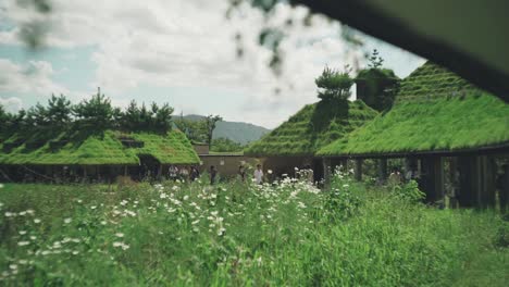 Tourists-Walking-Around-The-Lush-Green-Roof-Building-In-La-Collina-At-The-Club-Harie-J'oublie-le-Temps-In-Shiga,-Japan