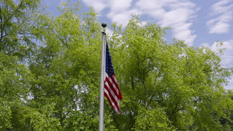 Low-angle-orbit-around-USA-flag-blowing-in-slow-motion