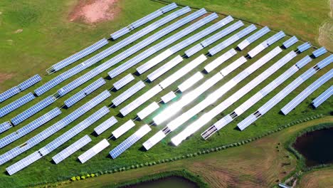 Solar-Power-Plant-On-Green-Field-Near-Trakai,-Lithuania---aerial-drone-shot