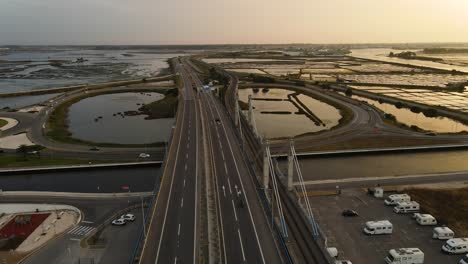 Aerial-footage-of-a-highway-bridge-and-its-surrounding-river-channels-and-salt-plans-in-Aveiro,-Portugal