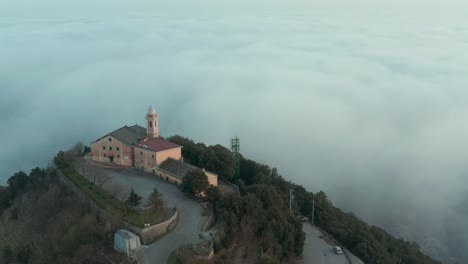 drone-flying-above-the-clouds-and-a-church-with-circular-movement