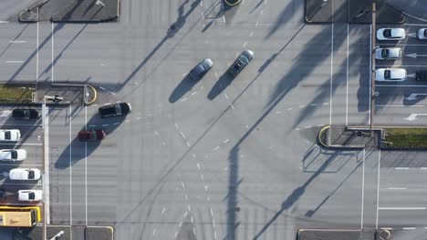 Cars-turning-left-on-large-intersection-in-Reykjavik,-top-down-aerial