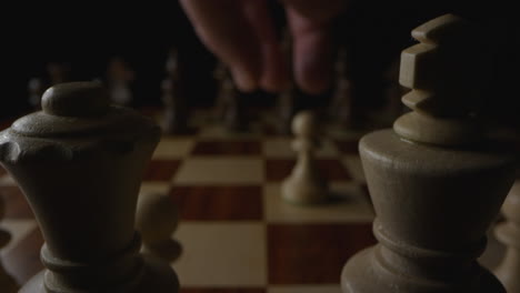Chess-player’s-hand-pick-up-pawn-piece-and-moves-it-backward-two-spaces-illegally