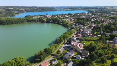 Aerial-backwards-shot-of-natural-lake,road-with-cars-and-small-village-near-Gdansk,Poland