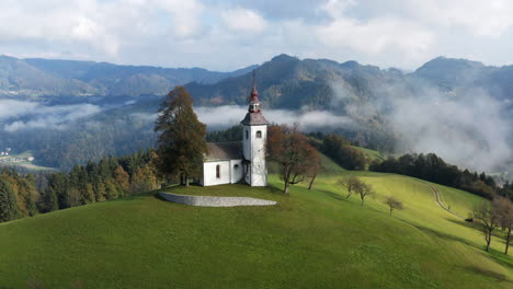 Nubes-Escénicas-Rodando-Temprano-En-La-Mañana-Con-La-Iglesia-De-Sveti-Tomaz-Cerca-De-Skofja-Loka-En-Eslovenia